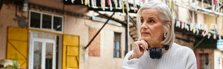 A thoughtful woman gazes into the distance, soaking up the vibrant urban atmosphere.の写真素材