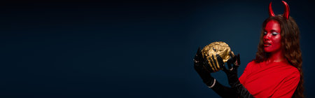 A captivating woman shows her Halloween spirit in a vibrant costume with a golden skull.の写真素材