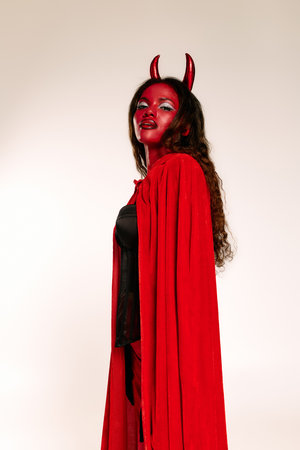 A stunning woman in red with devil horns shows off her Halloween spirit at a festive event.