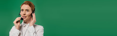 A confident woman speaks into a headset, dressed in a white shirt, set against a lively green backdrop.の写真素材