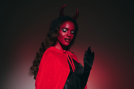 In an enchanting Halloween celebration, a beautiful woman captivates with her devil themed costume.