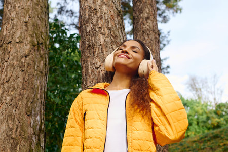 A young woman revels in the beauty of autumn while hiking through a colorful forest.の写真素材