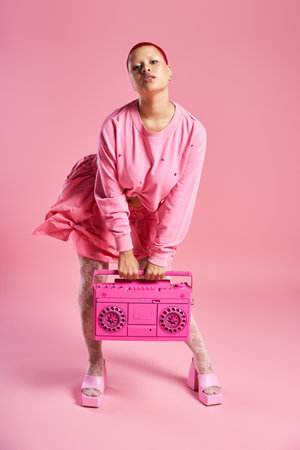 A confident young woman exudes boldness while holding a boombox, capturing the essence of vibrant fashion.の写真素材