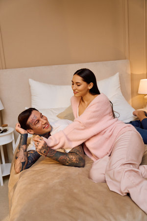 Young couple relaxes together, exchanging smiles and laughter in their intimate space.の写真素材