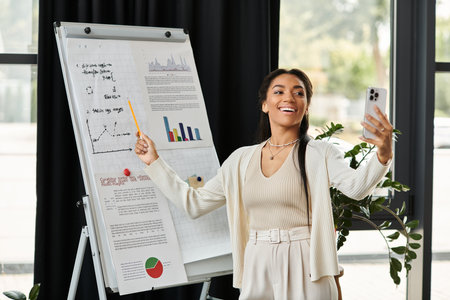 A young woman excitedly presents, engaging her audience while holding a smartphone.の写真素材
