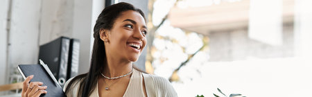 In a bright office, a young woman joyfully engages in her tasks, radiating positivity.