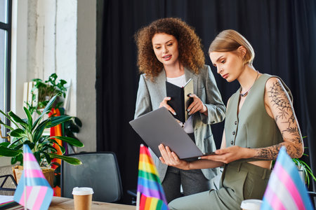 Two coworkers discuss a project together, embracing inclusivity and diversity in their workspace.の写真素材