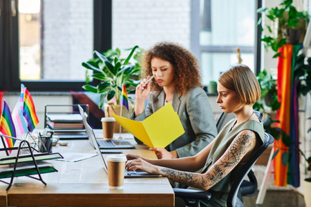 Two colleagues engage in a productive work environment filled with vibrant expressions of identity.の写真素材