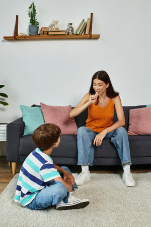 A mother communicates with her hearing impaired son, fostering a loving connection at home.の写真素材