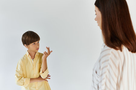 A little boy communicates through sign language, expressing his thoughts to his caring mother.の写真素材