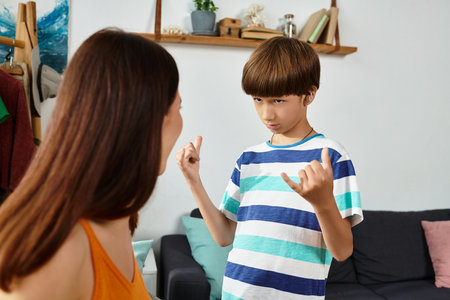 A little boy joyfully communicates with his mother in their cozy living room.の写真素材