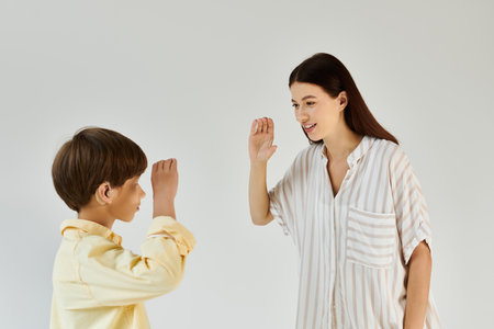 A young boy with hearing impairment engages in a joyful moment with his mother, using sign language.