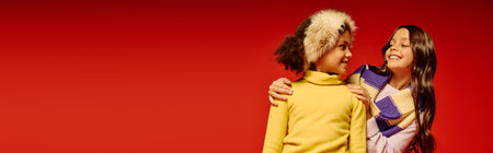 Two cheerful kids in warm sweaters share smiles and holiday spirit during a Christmas celebration.