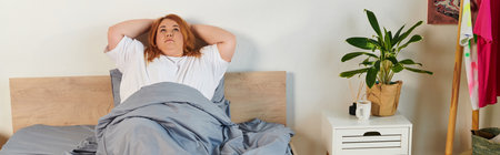 A surprised plus size woman sits upright in soft bedding.