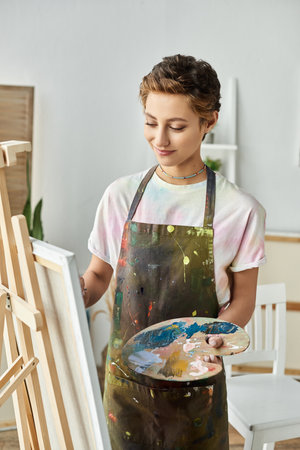 In a bright and inspiring space, a young woman creates a painting, expressing her passion for art.の写真素材
