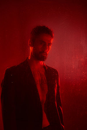 Attractive man in suit posing in red lights.