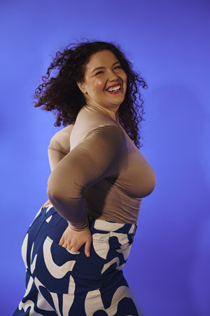 A stunning plus size woman joyfully poses, showcasing her curvy silhouette and vibrant personality.