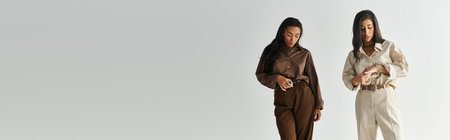 Two young women dressed in chic outfits display their stylish flair while posing gracefully.