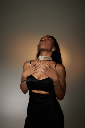 A fashionable young woman poses gracefully, showcasing her elegant outfit and unique style.