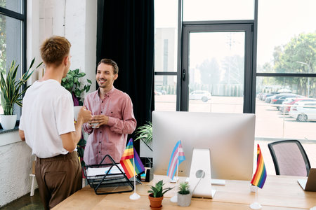 Two handsome men engage in cheerful conversation, surrounded by colorful decor and plants.の写真素材