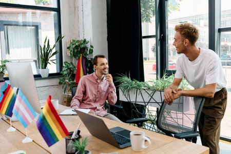 A handsome couple engages in a light hearted conversation in a colorful workspace.の写真素材