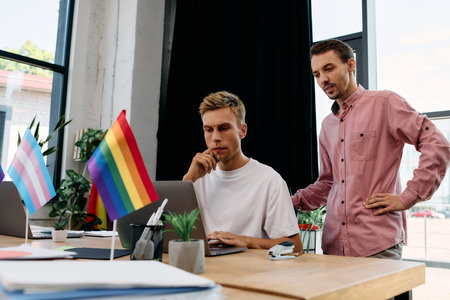 Engaged in a deep discussion, two handsome men collaborate in a stylish office filled with colors.の写真素材