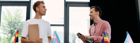 Two men engage in a lively conversation, radiating happiness and love, amidst pride flags.の写真素材