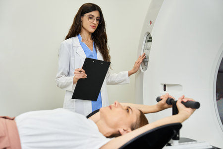 Doctor in lab coat assists patient during MRI scan, ensuring comfort and accuracy in diagnostics.の写真素材