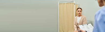 A gynecologist engages with a female patient in a well-equipped clinic, ensuring her health.の写真素材