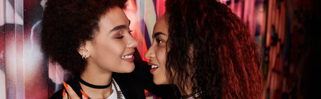 Two friends enjoy a lively interaction against a colorful backdrop, radiating happiness.