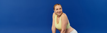 A cheerful woman in a crop top enjoys her workout, radiating energy in a colorful studio environment.の写真素材