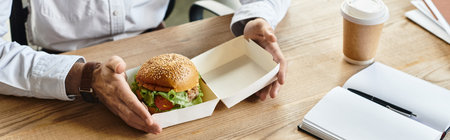 professional in a white shirt takes a moment to savor a burger while working on a project.