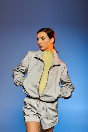 Fashionable woman with trendy makeup showcases her outfit in a vibrant studio setting.