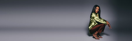 A beautiful young Black woman poses elegantly in a stylish studio, highlighting her fashion, bannerの写真素材