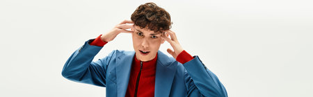 Handsome man in a sleek blue suit expresses personality with a striking red top in a modern space.