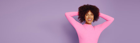 A young African American woman expresses pure joy in her pink clothing, radiating positivity against...