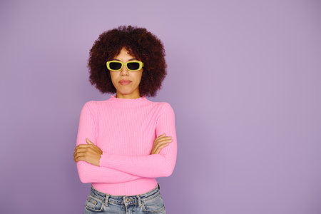 A young African American woman in casual pink clothing displays strong emotions with a vibrant...