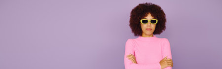 A young African American woman showcases her unique style while posing confidently in pink attire.の写真素材