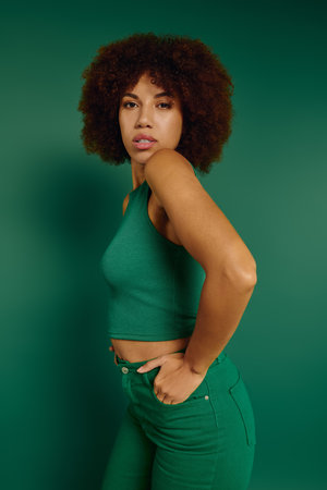 A pretty young woman wearing casual clothing in front of a green background.の写真素材