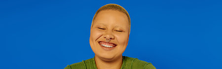 A young, fashionable woman beams with happiness, showcasing her unique style in a vibrant setting.
