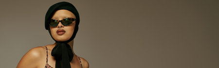 A young woman highlights her style with bold fashion and chic accessories while posing.の写真素材