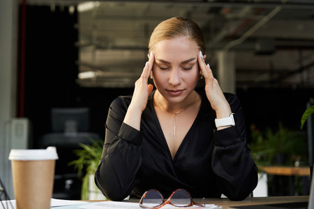 A young, beautiful plus size woman works diligently at her desk, deep in thought.の写真素材