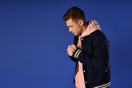 Young man stands in a relaxed pose, reflecting on life in a modern setting.
