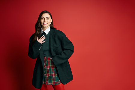 Smiling young woman dressed in a chic ensemble showcases her fashion sense and charisma.の写真素材
