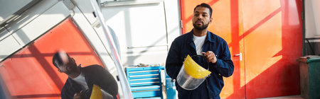 Young mechanic showcases his skills while working with equipment in a bright garage.