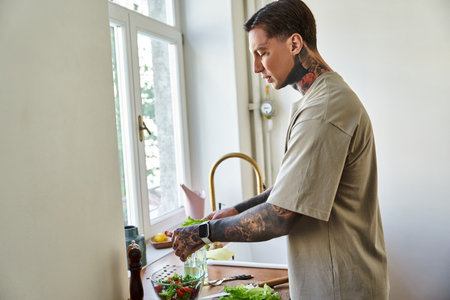 The young man skillfully chops vegetables while enjoying a sunny day at home.の写真素材