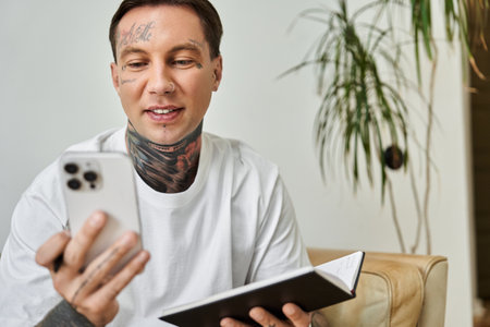 A young man enjoys a moment at home as he interacts with his smartphone, smiling and relaxed.の写真素材