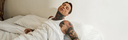A young handsome man unwinds peacefully in his tidy bedroom as morning light floods in.