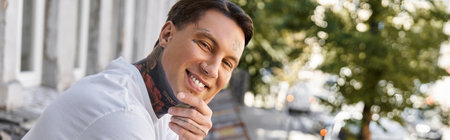 In a cozy home setting, a young man smiles joyfully while resting during daylight hours.の写真素材