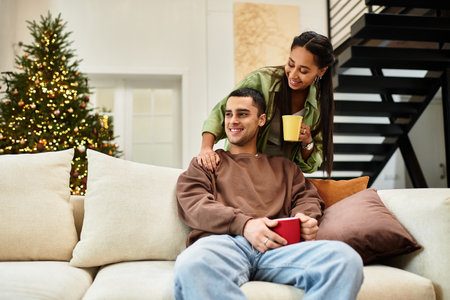 A couple enjoys each others company in their modern, decorated living space for Christmas.の写真素材